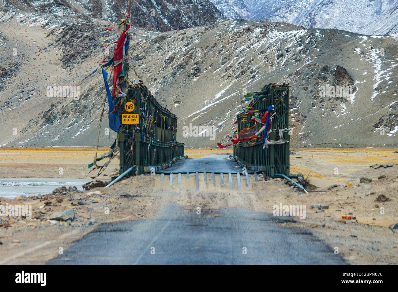 Un ponte di ferro rivestito che collega le strade nazionali delle autostrade in Ladakh, Jammu & Kashmir, India, Asia. Le montagne di neve in Ladakh sono incredibili. Foto del paesaggio. Foto Stock