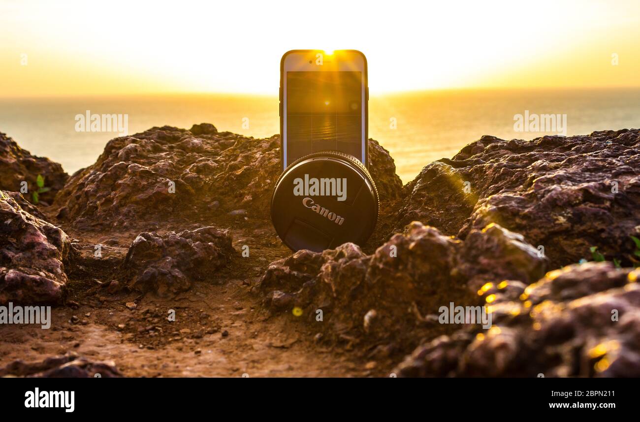 Un iPhone 7 che riprende il tramonto sulla spiaggia di Vagator mantenendo il suo equilibrio con un obiettivo canon. Il verde paesaggio del nord di Goa è solo una vista da sogno Foto Stock