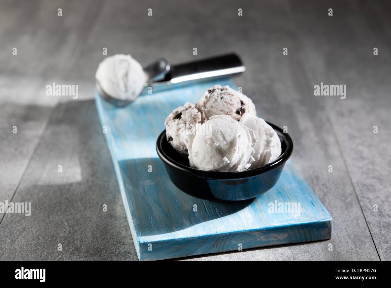 Latticini e gelati stracciatella in ciotola da dessert nera Foto Stock