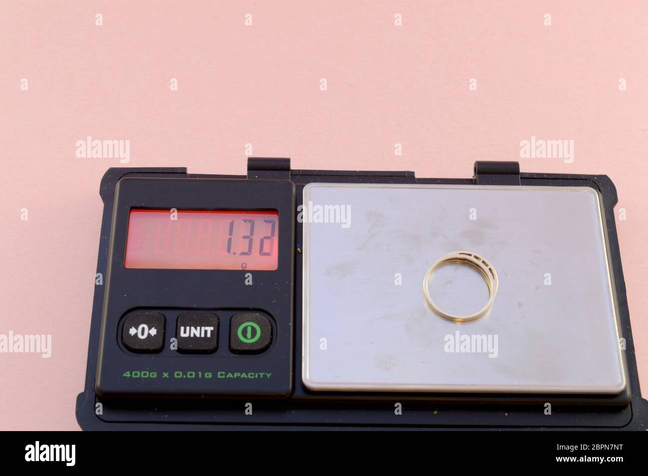 Un set di bilance digitali pesa un anello d'oro che verrà venduto per gli scarti. Foto Stock
