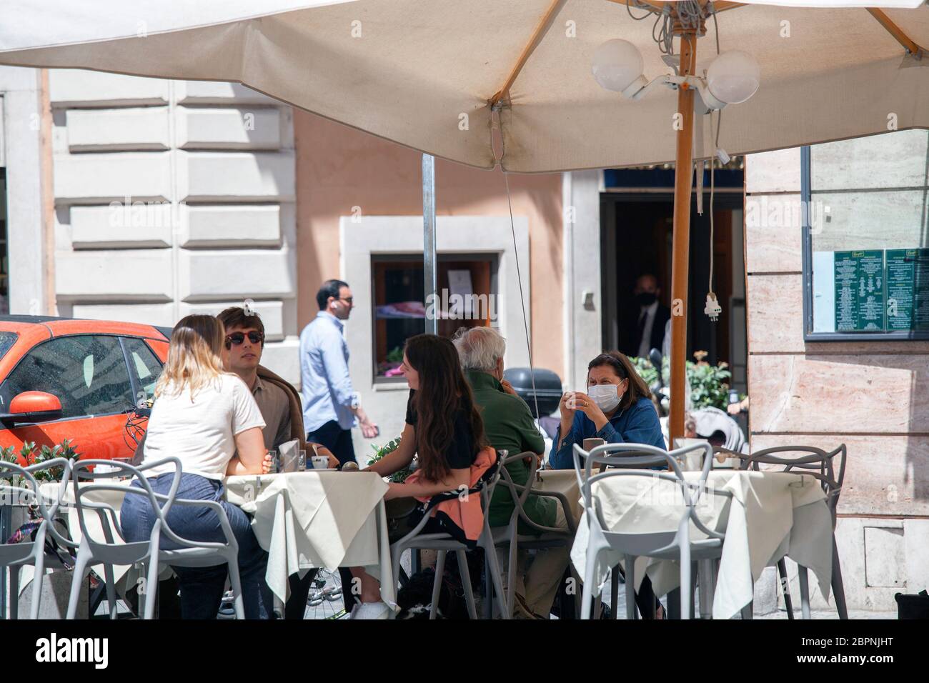 I clienti si siedono ai tavoli in una zona terrazza fuori dai caffè di Roma, Italia, martedì 19 maggio 2020. Negozi e ristoranti riaprono mentre l'Italia facilita ulteriormente Lockdown nella fase 2 Foto Stock