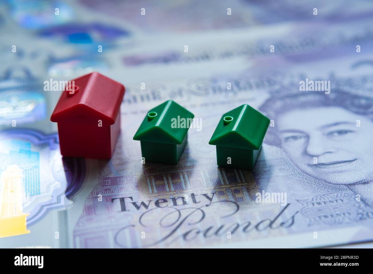 La casa giocattolo rossa si è posta sopra 20 banconote inglesi. Foto macro. Immagine concettuale per UK House Price Index, First home, ipoteca, immobiliare o h. Foto Stock