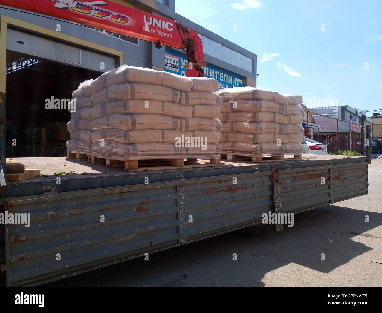 Krasnodar, Russia - 13 giugno 2019: Scarico di sacchi di cemento da un camion con un carrello elevatore. Foto Stock