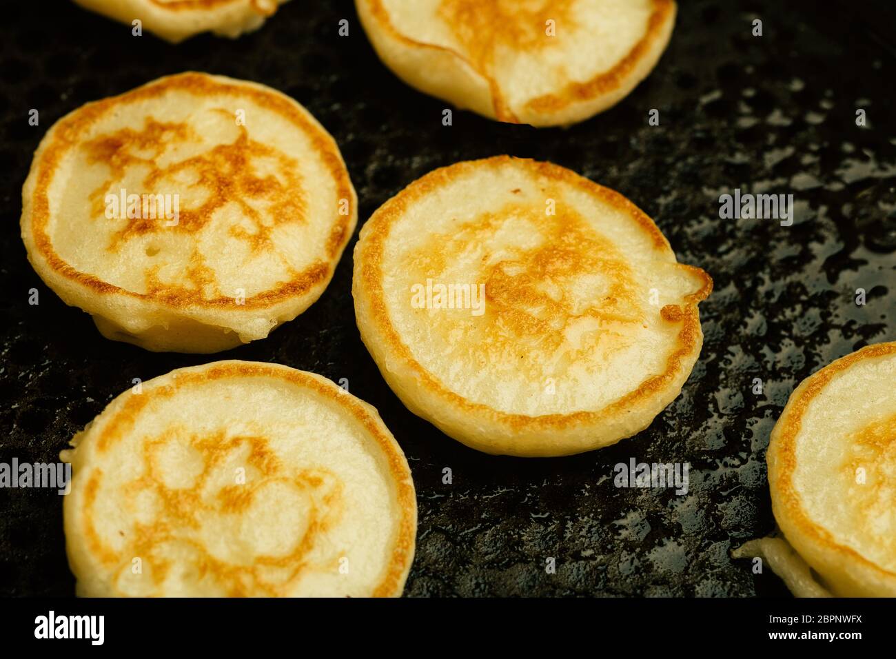 Minuscoli pancake per colazione. Minuscoli pancake cucinati in una padella in cucina. Foto Stock