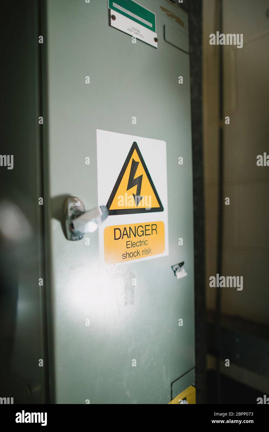 Immagine ravvicinata di un recinto elettrico casella con un segno di avvertimento. Foto Stock
