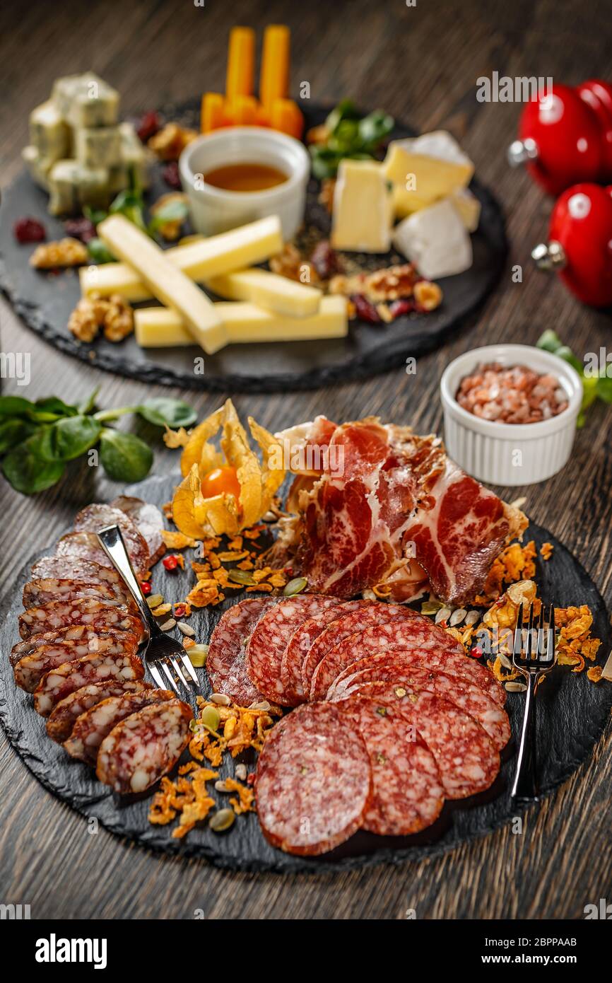 Vassoio per alimenti con deliziosi salami, pezzi di fettine di prosciutto e salsiccia Foto Stock