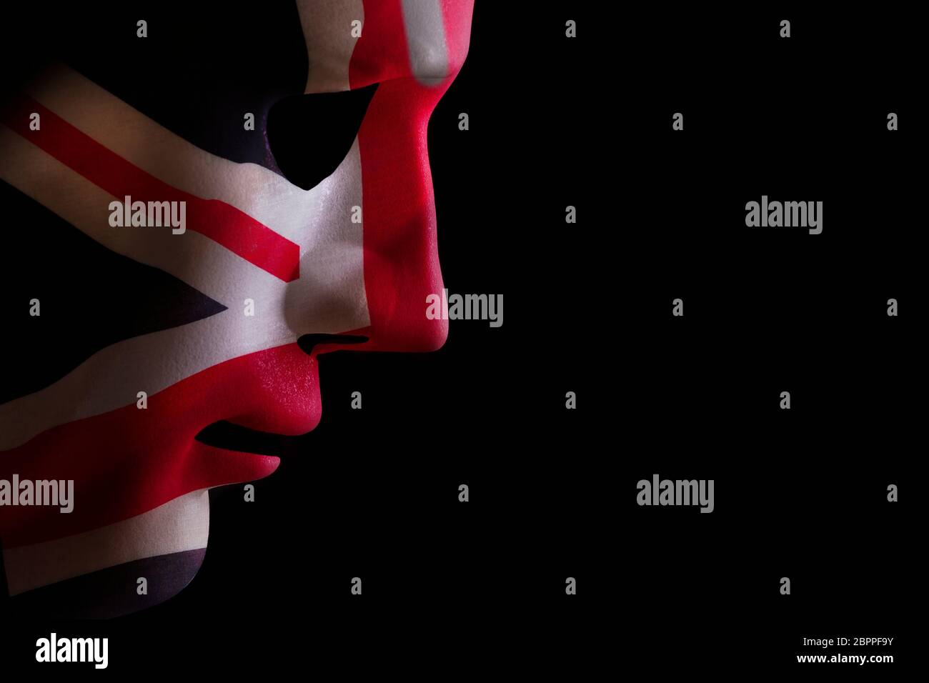 Maschera facciale profilo con una bandiera dell'union jack texture guardando in giù su un nero blackground. Spazio per il testo Foto Stock