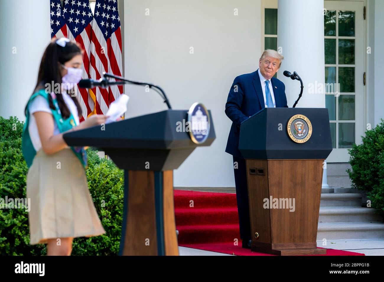 Il presidente degli Stati Uniti Donald Trump ascolta la ragazza Scout Laila Khan, cui hanno aderito i 744 membri della commissione Girl Scout Lauren Matney e Sravya Annappareddy, durante la cerimonia di riconoscimento presidenziale: Duro lavoro, eroismo e speranza nel Rose Garden della Casa Bianca 15 maggio 2020 a Washington, D.C. l'evento ha onorato i lavoratori di prima linea che combattono il COVID-19, pandemia del coronavirus. Foto Stock