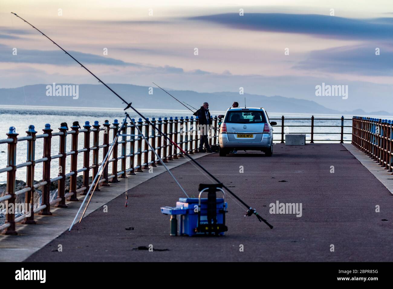 Morecambe, Lancashire, Regno Unito. 19 maggio 2020. Pescatori fuori pesca sul Grosvenor Breakwater al tramonto dopo una giornata di bluastra il tempo ha preso permettendo ai pescatori di godere di una piacevole serata sulla passeggiata a Morecambe Credit: PN News/Alamy Live News Foto Stock