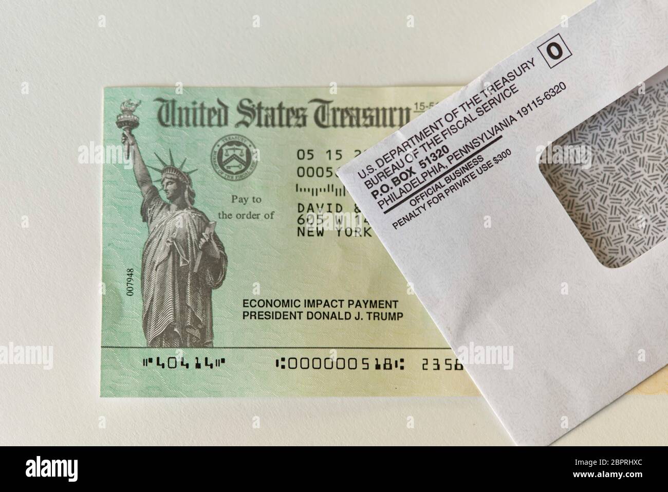 Vista di un controllo di pagamento di impatto economico e busta inviata dall'IRS alla maggior parte degli americani e residenti degli Stati Uniti per aiutare ad alleviare gli effetti del Covid-19 Foto Stock