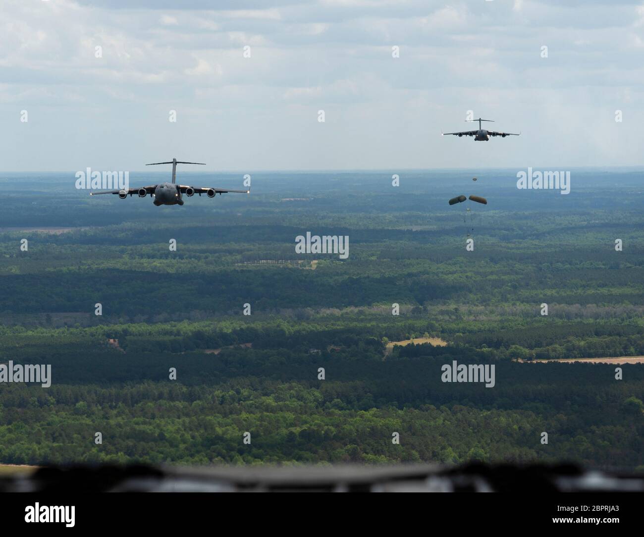 Due US Air Force C-17 Globemaster IIIs assegnati alla 437a Airlift Wing eseguono un airdrop sopra North Auxiliary Airfield, South Carolina, dopo aver condotto un volo di strutture mediche locali come parte DI FUNZIONAMENTO: AMERICA STRONG, 15 maggio 2020. USA Air Force OPERATION: L'AMERICA STRONG è tenuto a salutare coloro che sono in prima linea della risposta COVID-19. (STATI UNITI Air Force foto di Airman First Class Duncan C. Bevan) Foto Stock