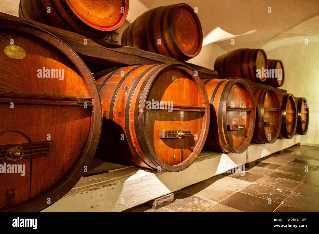 Antica cantina. Pila delle botti di vino in una cantina di vini. Vecchie botti in legno con il vino in un archivio di vino. Botti da vino impilati nella vecchia cantina del wi Foto Stock