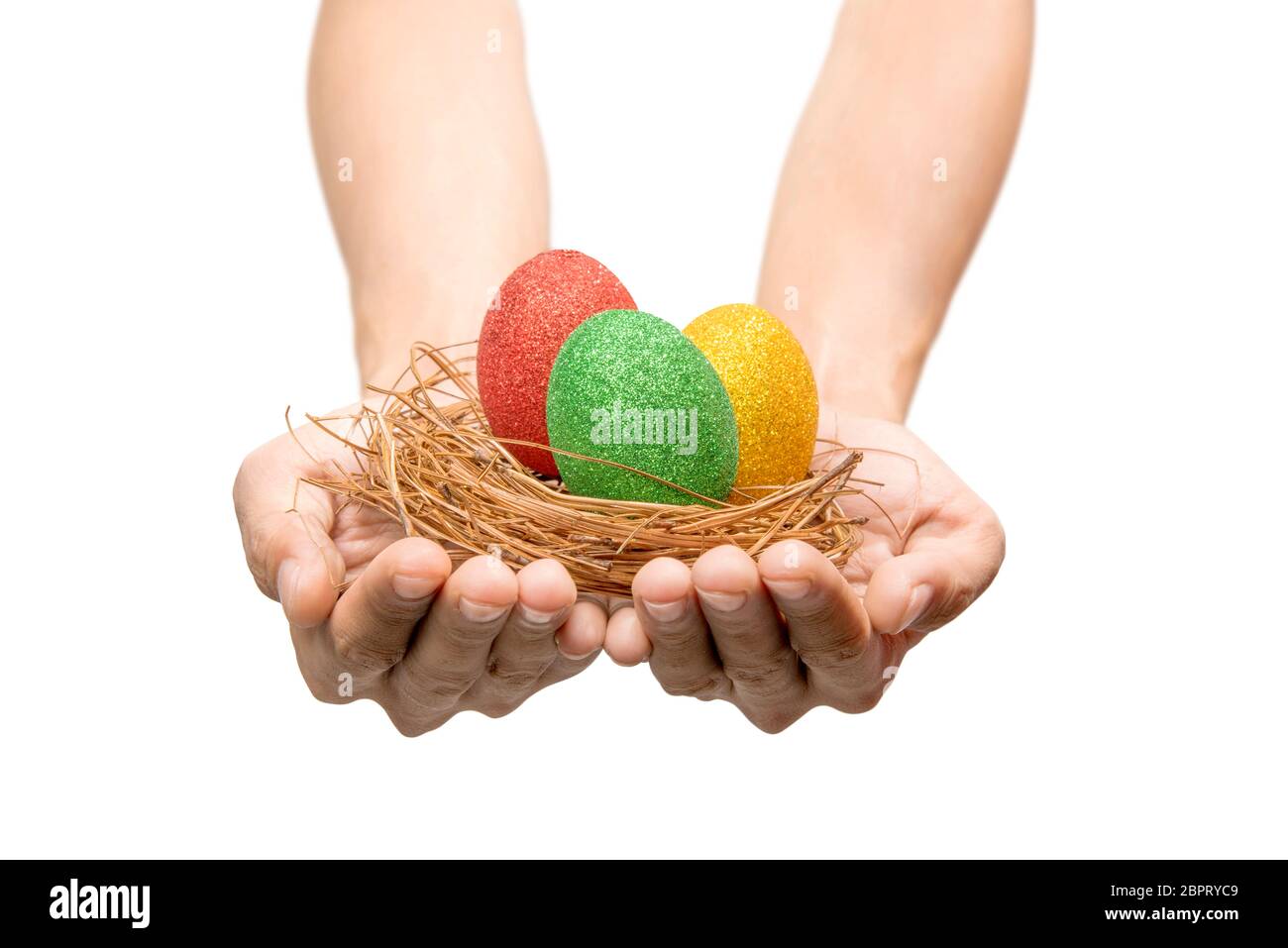 Le mani umane holding nest con colorate uova di pasqua isolate su sfondo bianco. Buona Pasqua Foto Stock