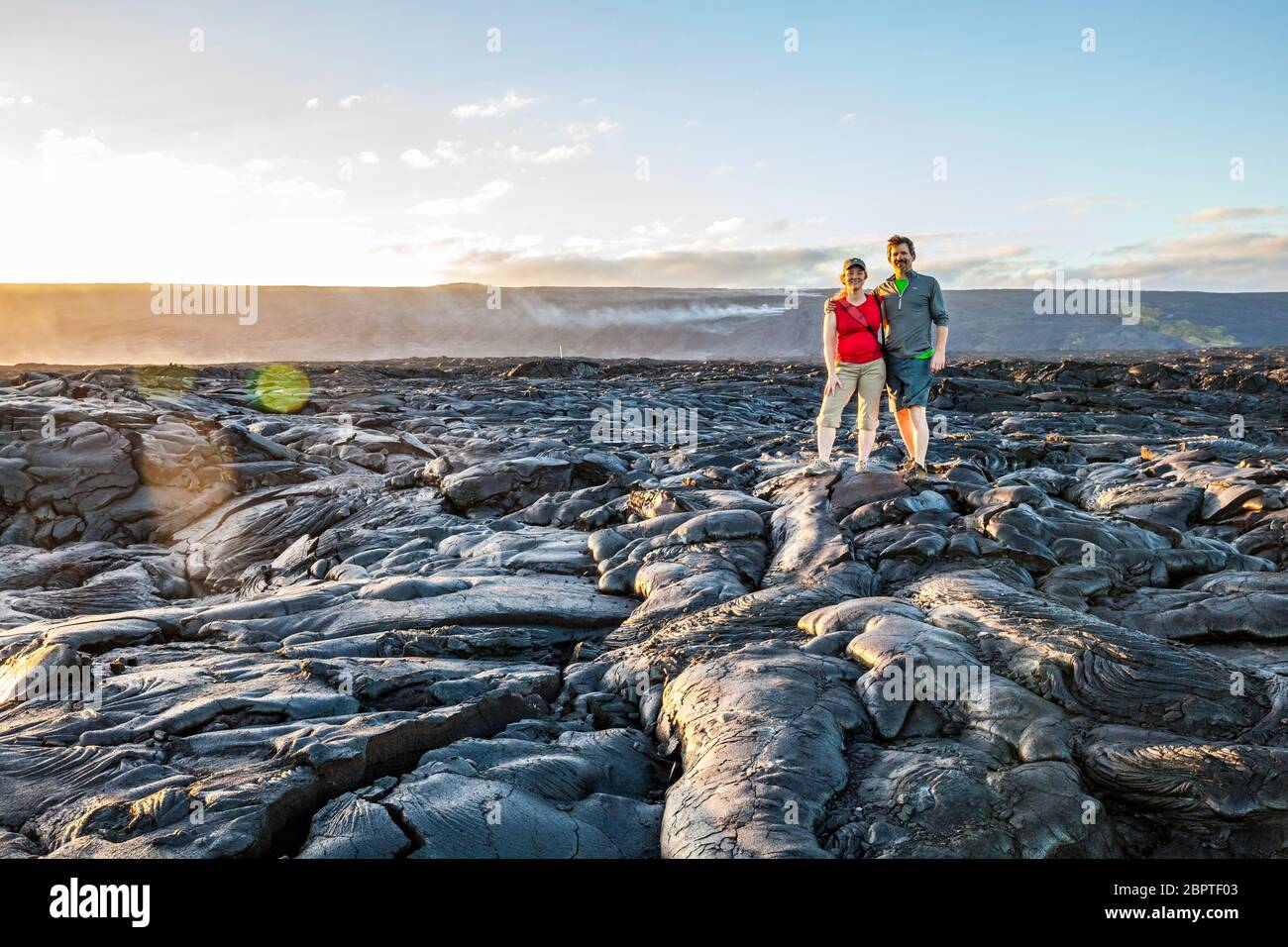 Una coppia che posa per una foto sui grandi campi di lava della zona di Rift orientale, 2017 mentre cammina verso il punto di ingresso dell'oceano di lava lungo la catena di Foto Stock