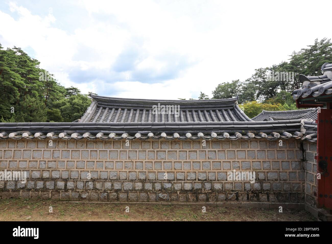 Tradizionale casa coreana tetto dietro il muro di pietra. Foto Stock