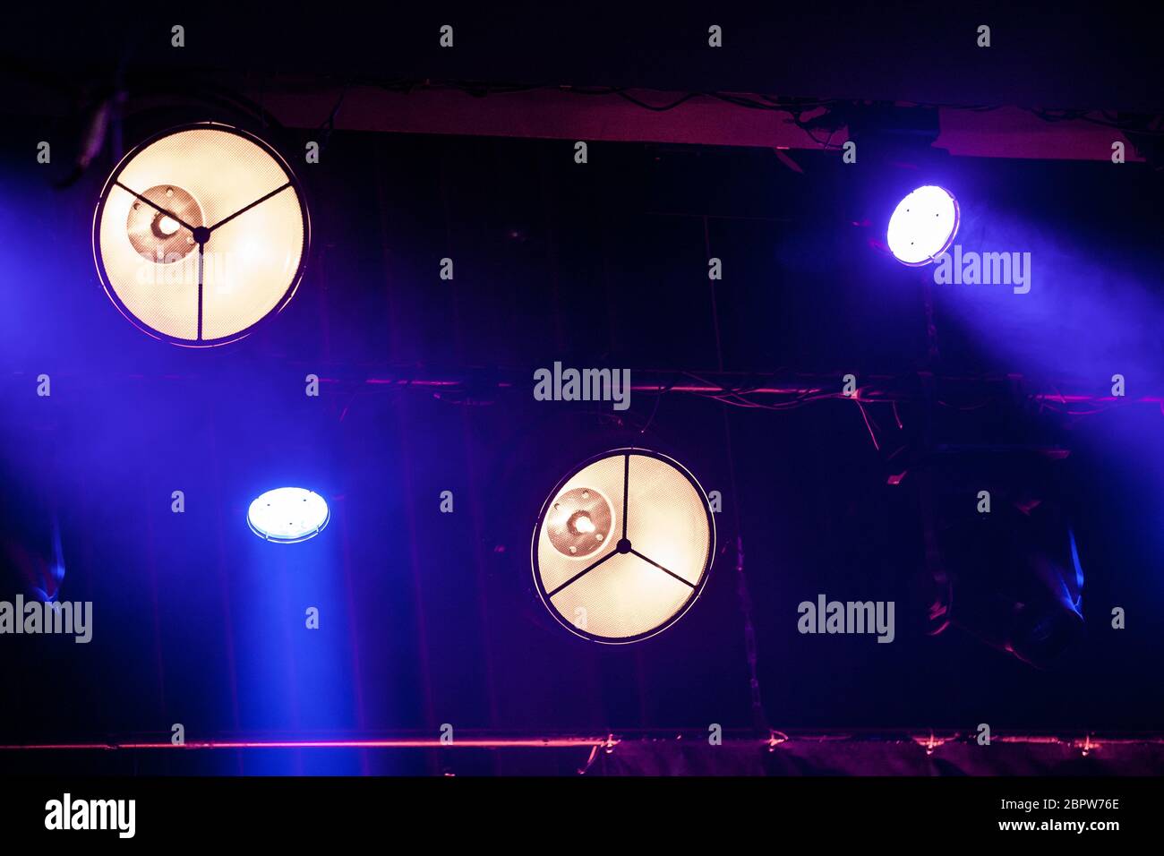 luci bianche e blu con proiettori che illuminano un palco da concerto Foto Stock