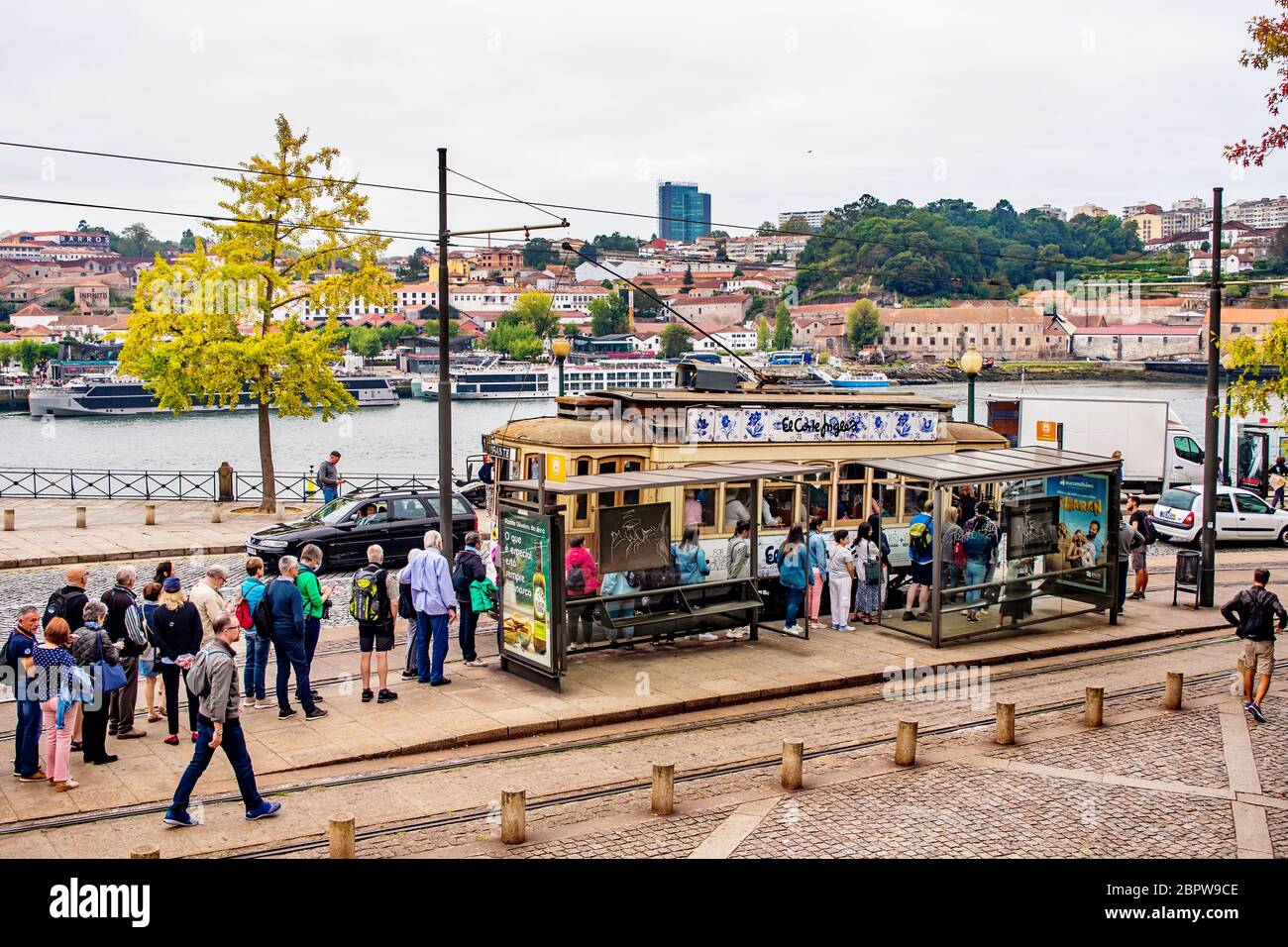 Una lunga fila di persone aspetta di salire a bordo del tram elettrico a Porto, in Portogallo Foto Stock
