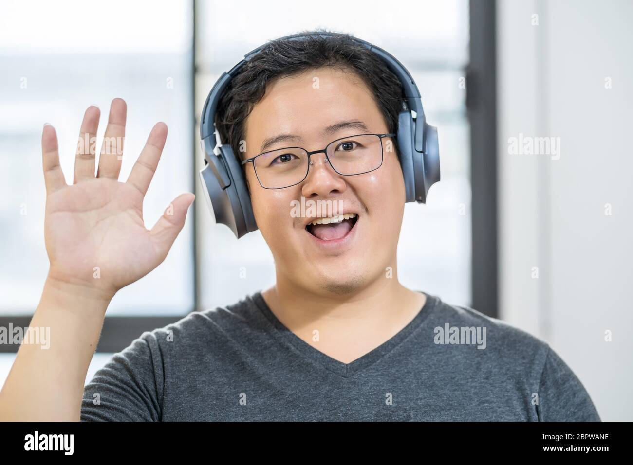 Uomo d'affari asiatico che sventola la mano per dire ciao quando fa la videochiamata ad un amico con la presa sociale, sorridente femmina che prende video blog che registra vlog, Foto Stock Uomo d'affari asiatico che sventola la mano per dire ciao quando fa la videochiamata ad un amico con la presa sociale, sorridente femmina che prende video blog che registra vlog, Foto Stock