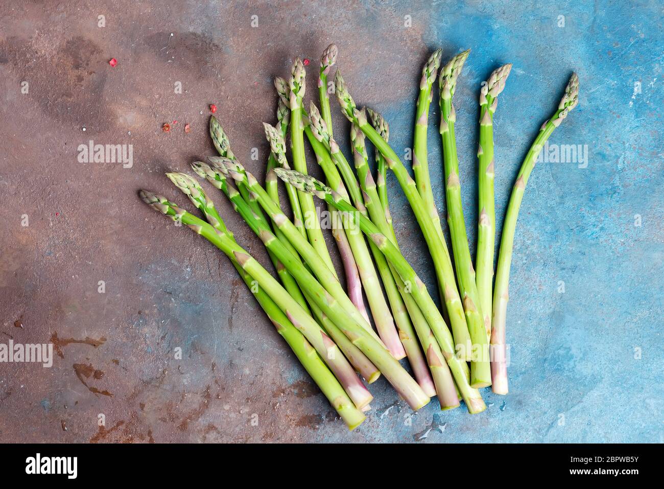 Le lance di asparagi verdi e naturali appena selezionate per cucinare cibi vegetariani sani su fondo di cemento scuro. Foto Stock