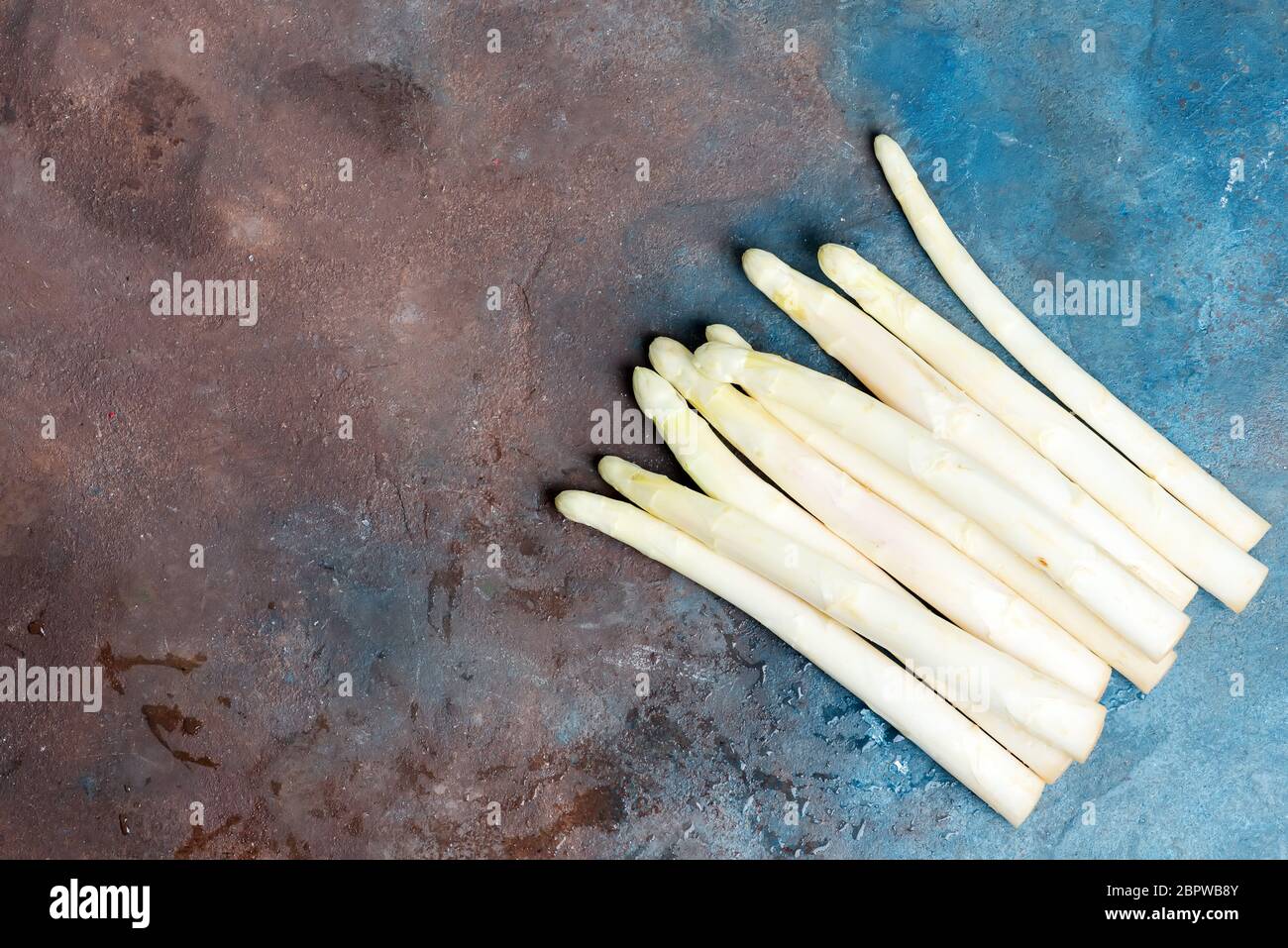 Le cesoie bianche di asparagi biologici appena selezionate per cucinare cibi vegetariani sani su fondo di cemento scuro. Foto Stock