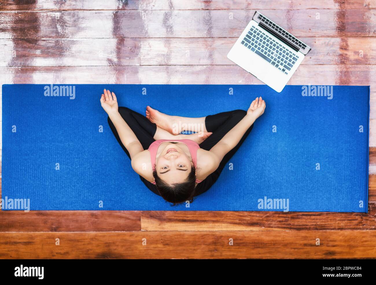 Vista dall'alto donna asiatica che pratica yoga da casa con computer portatile quando Covid19 focolaio, esercizio di salute o meditazione, allenamento a casa, coronavirus pandemi Foto Stock Vista dall'alto donna asiatica che pratica yoga da casa con computer portatile quando Covid19 focolaio, esercizio di salute o meditazione, allenamento a casa, coronavirus pandemi Foto Stock