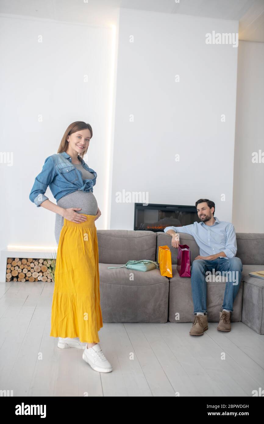 Giovane donna incinta con una gonna gialla Foto Stock
