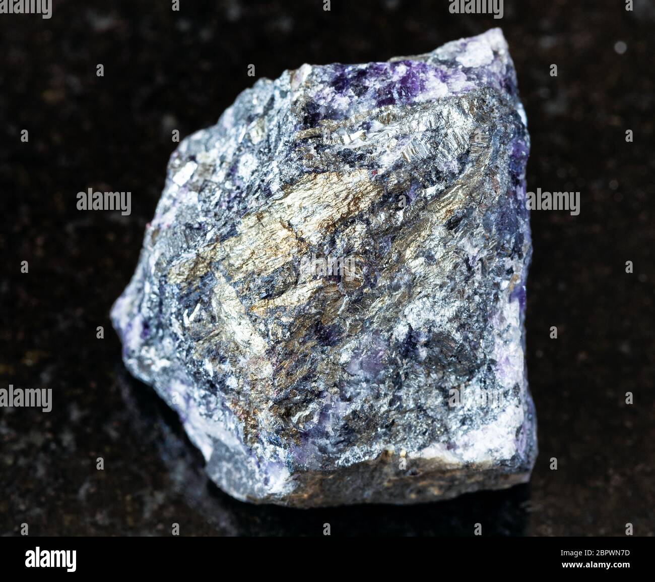 Primo piano di campione di minerale naturale da raccolta geologica - stibbnite ruvida (Antimonite) minerale su fondo di granito nero da Ucraina Foto Stock