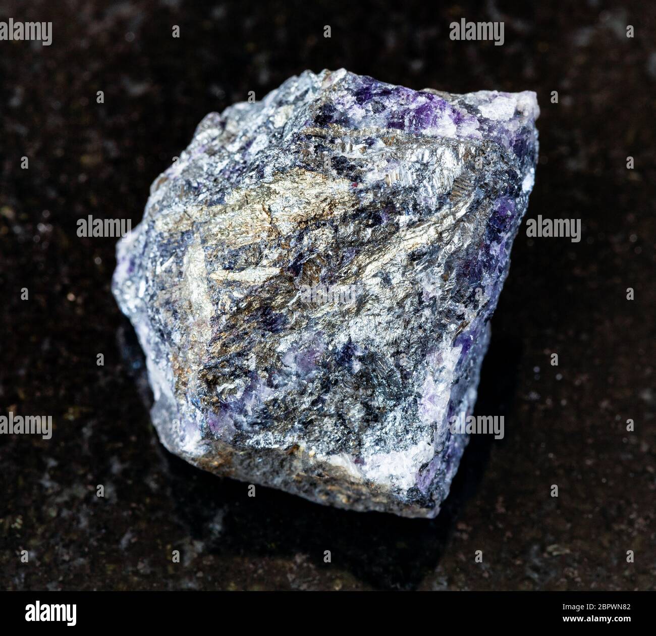 Primo piano di un campione di minerale naturale proveniente dalla collezione geologica - stibnite non lucidata (antimonite) su fondo di granito nero dall'Ucraina Foto Stock