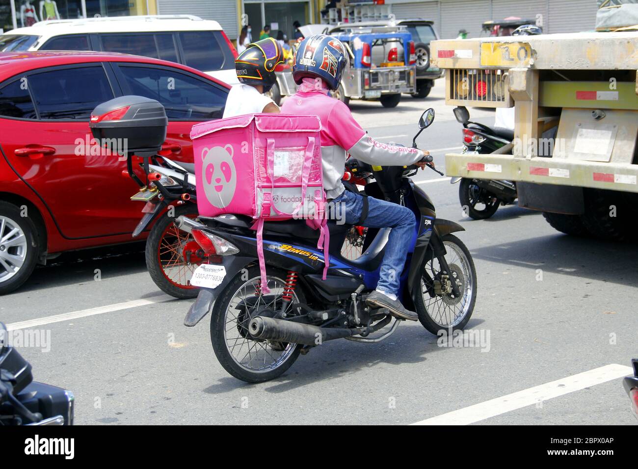 Antipolo City, Filippine - 16 maggio 2020: Il conducente che consegna il cibo del motociclo trasporta gli ordini del cliente durante l'epidemia di virus Covid 19. Foto Stock