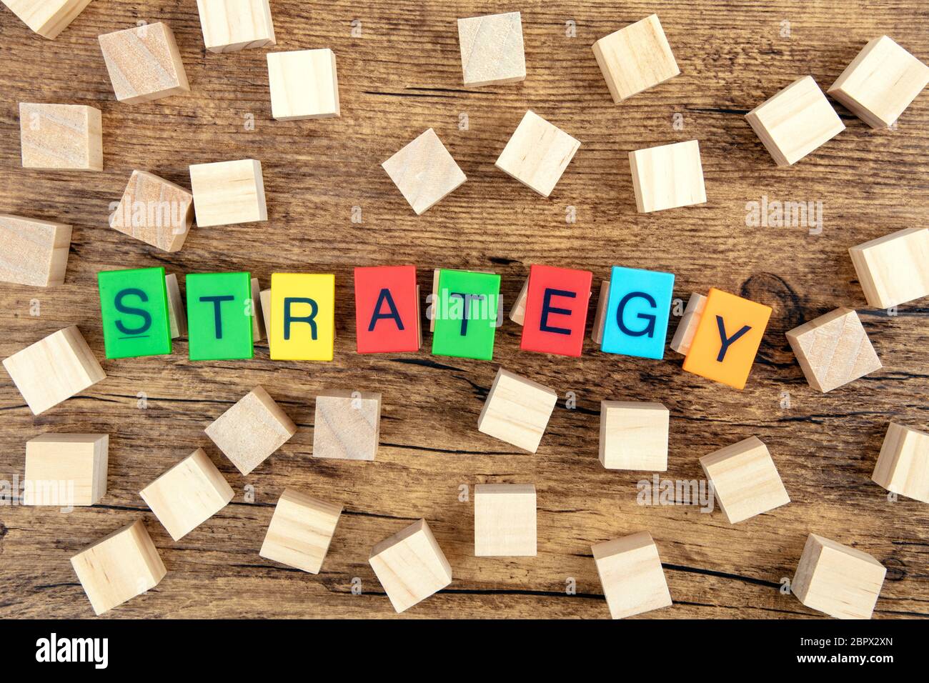 Il concetto: la strategia di plastica colorata lettere illustra la strategia di parola con il giocattolo di legno cubi Foto Stock