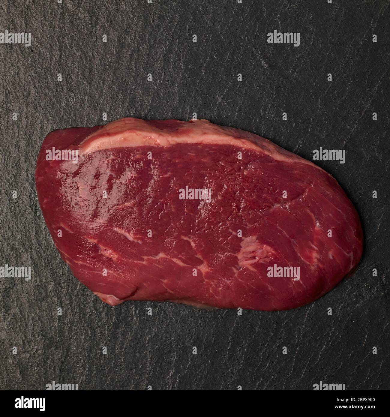 Bistecca di manzo scozzese, taglio crudo su sfondo ardesia Foto Stock