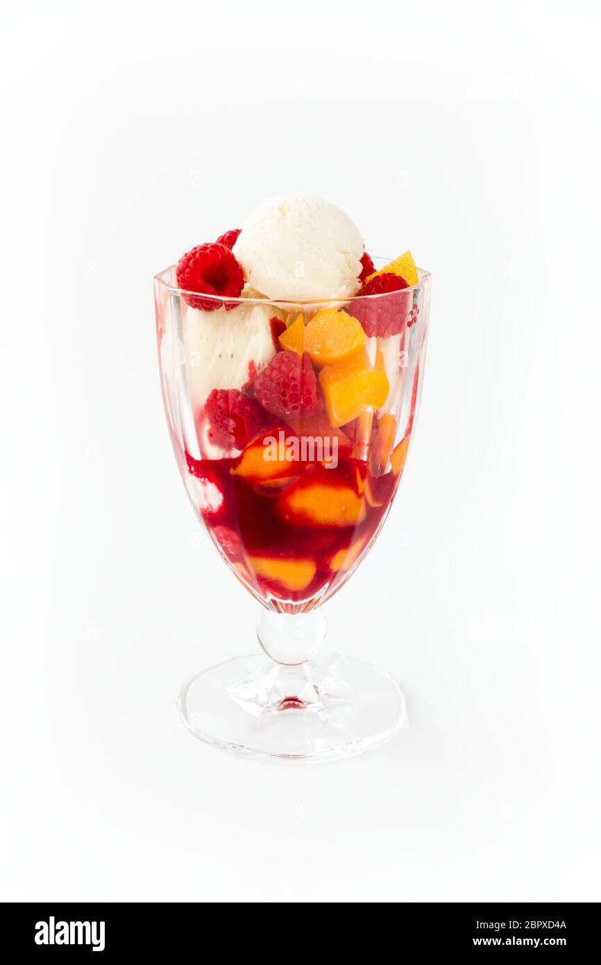 Gelato alla vaniglia con pesche, lamponi e salsa di lamponi. Pesca Melba isolato su bianco. Foto Stock