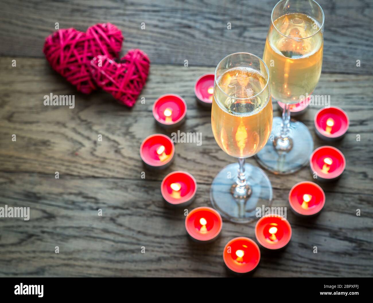Due bicchieri di champagne all'interno di candele accese Foto Stock