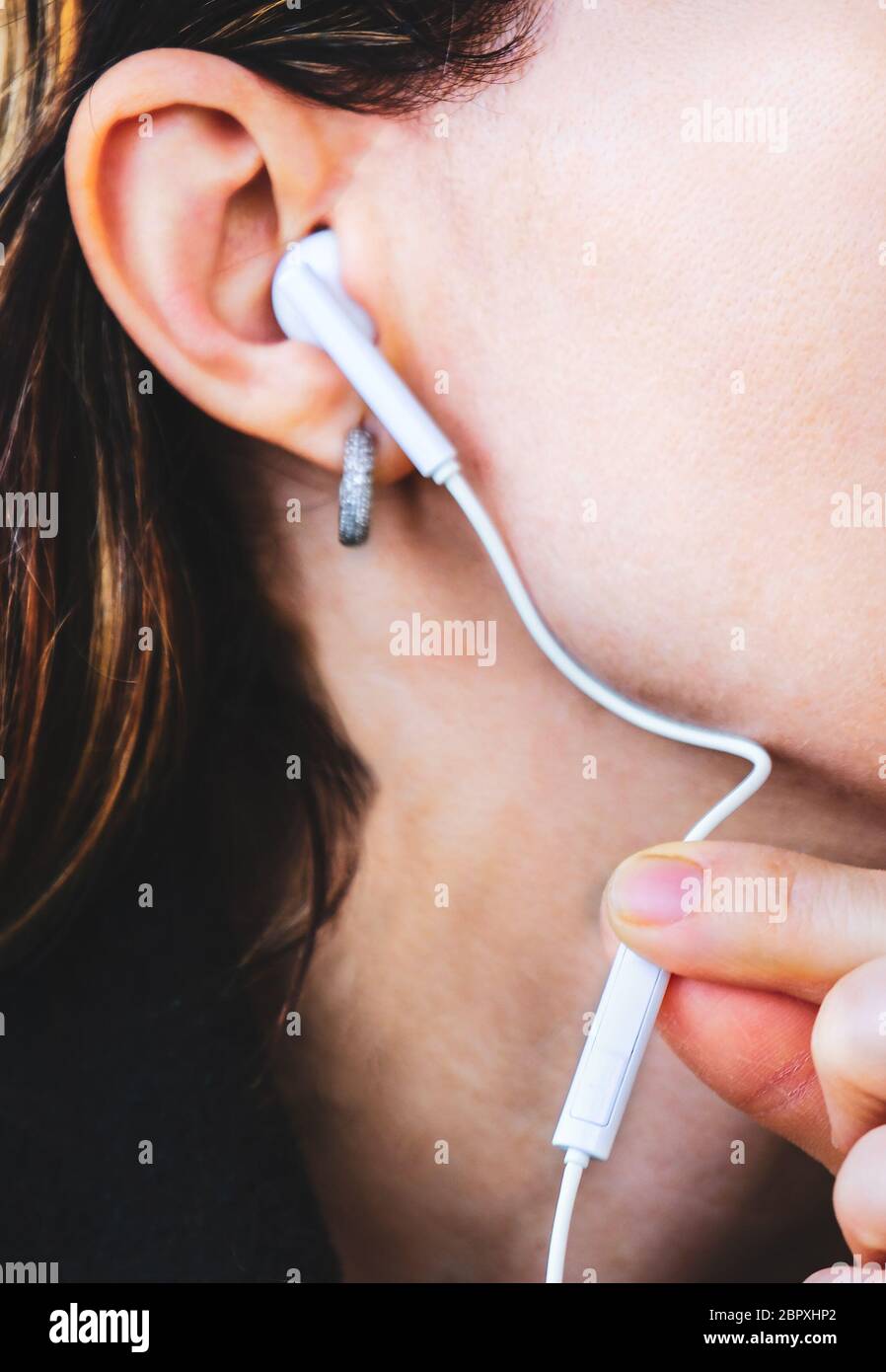 Toccare auricolare premere volume forza vicino donna isolamento audio . Foto Stock