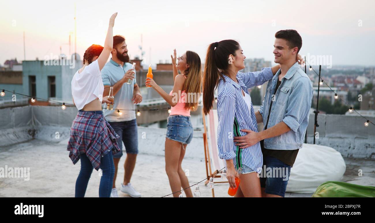 Gruppo di amici felice avente parte sul tetto Foto Stock