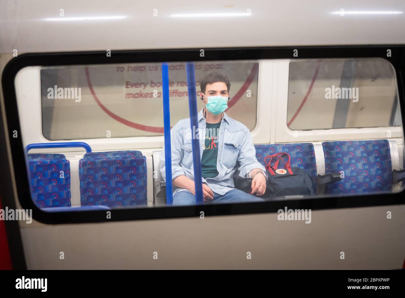 Un passeggero che indossa una maschera protettiva su un treno sotterraneo Northern Line durante l'ora di punta della mattina dopo l'introduzione di misure per portare il paese fuori dalla zona di blocco. Foto Stock