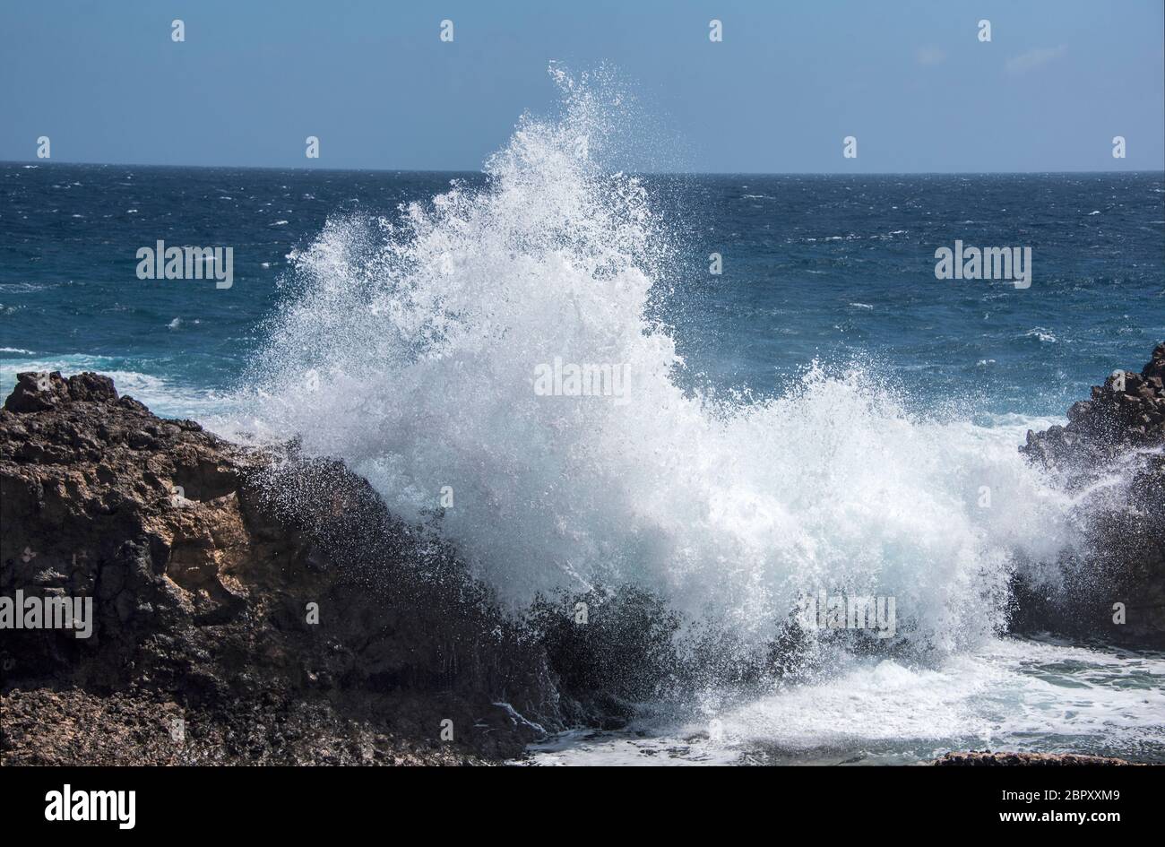 Grande onda che si schiantano contro le rocce vulcaniche a Lanzartote, Isole Canarie. Foto Stock