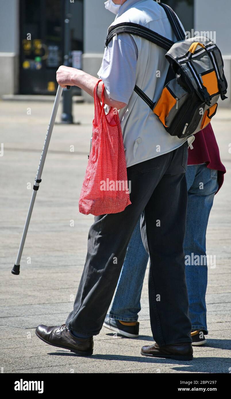La coppia anziana cammina indossando una maschera protettiva Foto Stock