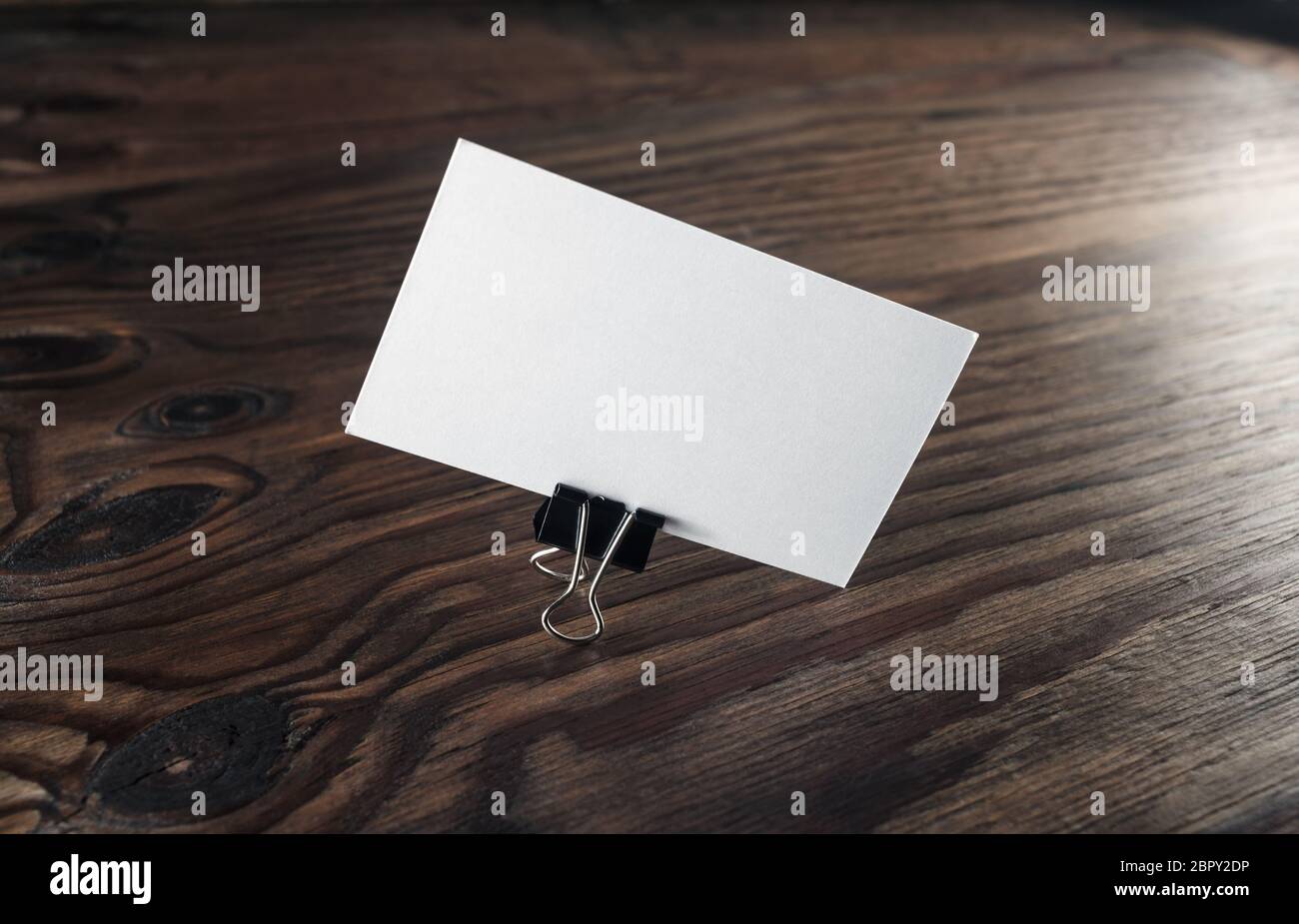 Blank business card con clip su sfondo di legno. Modello per ID. Identity design. Foto Stock