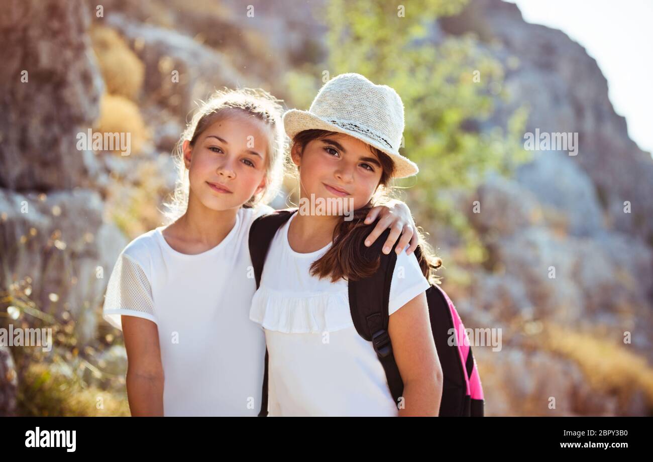 Ritratto di due cute ragazze della scuola all aperto con zaini, trascorre le vacanze in campeggio estivo, felice infanzia attivo Foto Stock