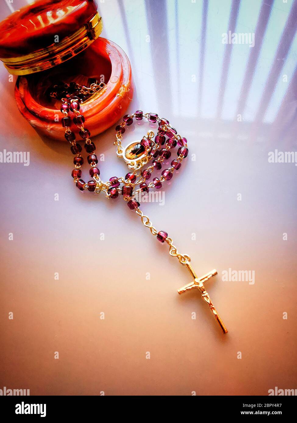 Collana trasversale con perle rosse su una scatola sul tavolo sotto le luci Foto Stock