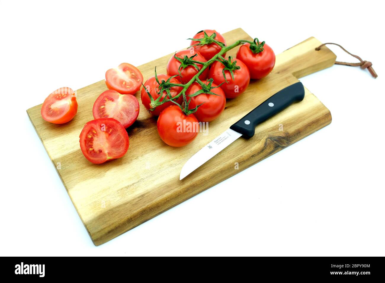 Legno di legno con pomodori e un coltello Foto Stock