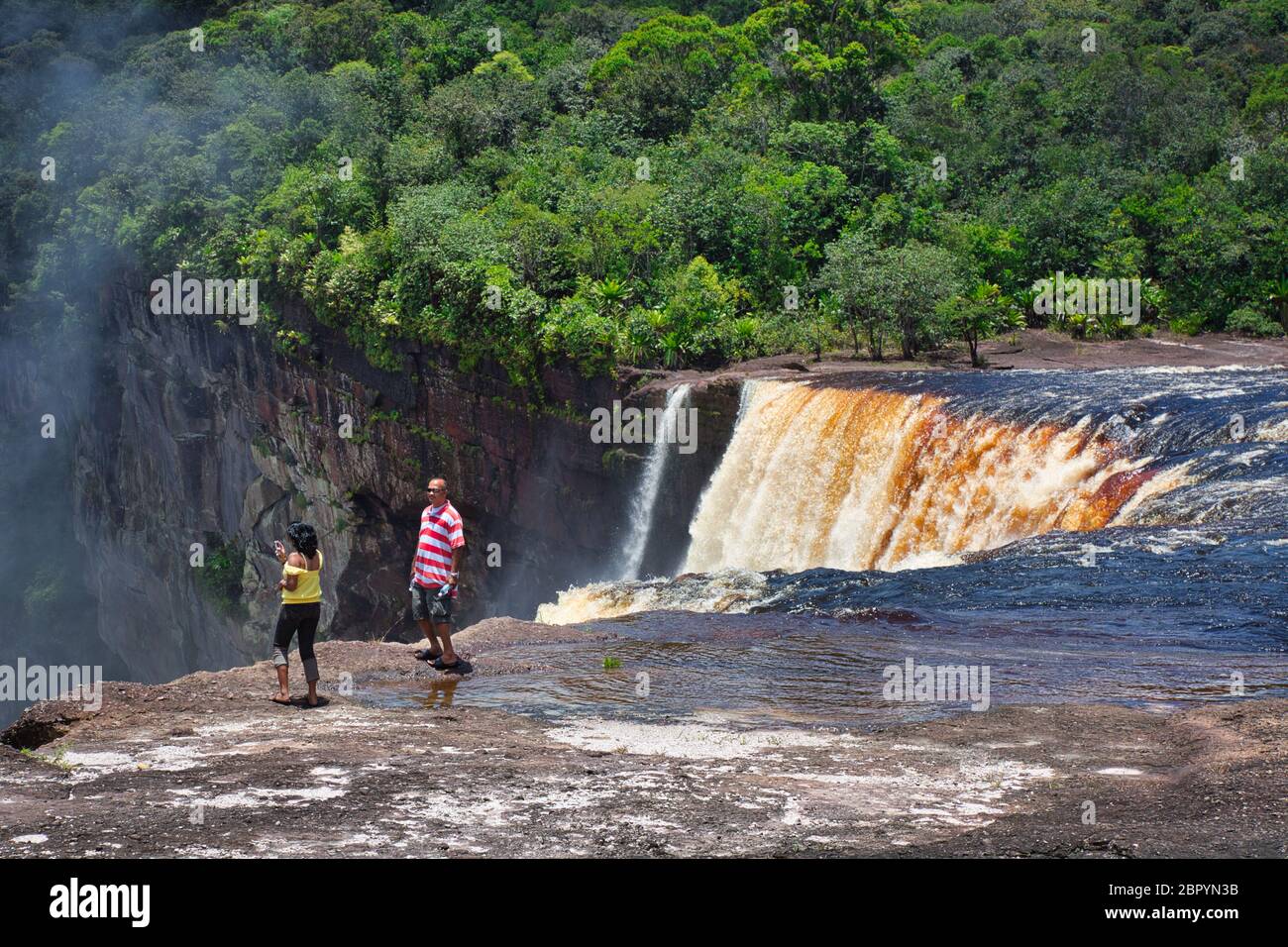 Cascate di Kieteur, nel Parco Nazionale di Kieteur, nella regione di Potaro-Siparuni, Guyana e parte della foresta pluviale amazzonica. Una coppia pagaia vicino alle cascate Foto Stock