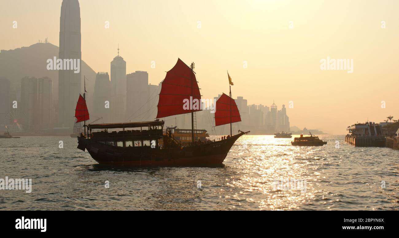 Victoria Harbour, Hong Kong 15 marzo 2019: Porto di Hong Kong Victoria e barca spazzatura a vela rossa in serata Foto Stock