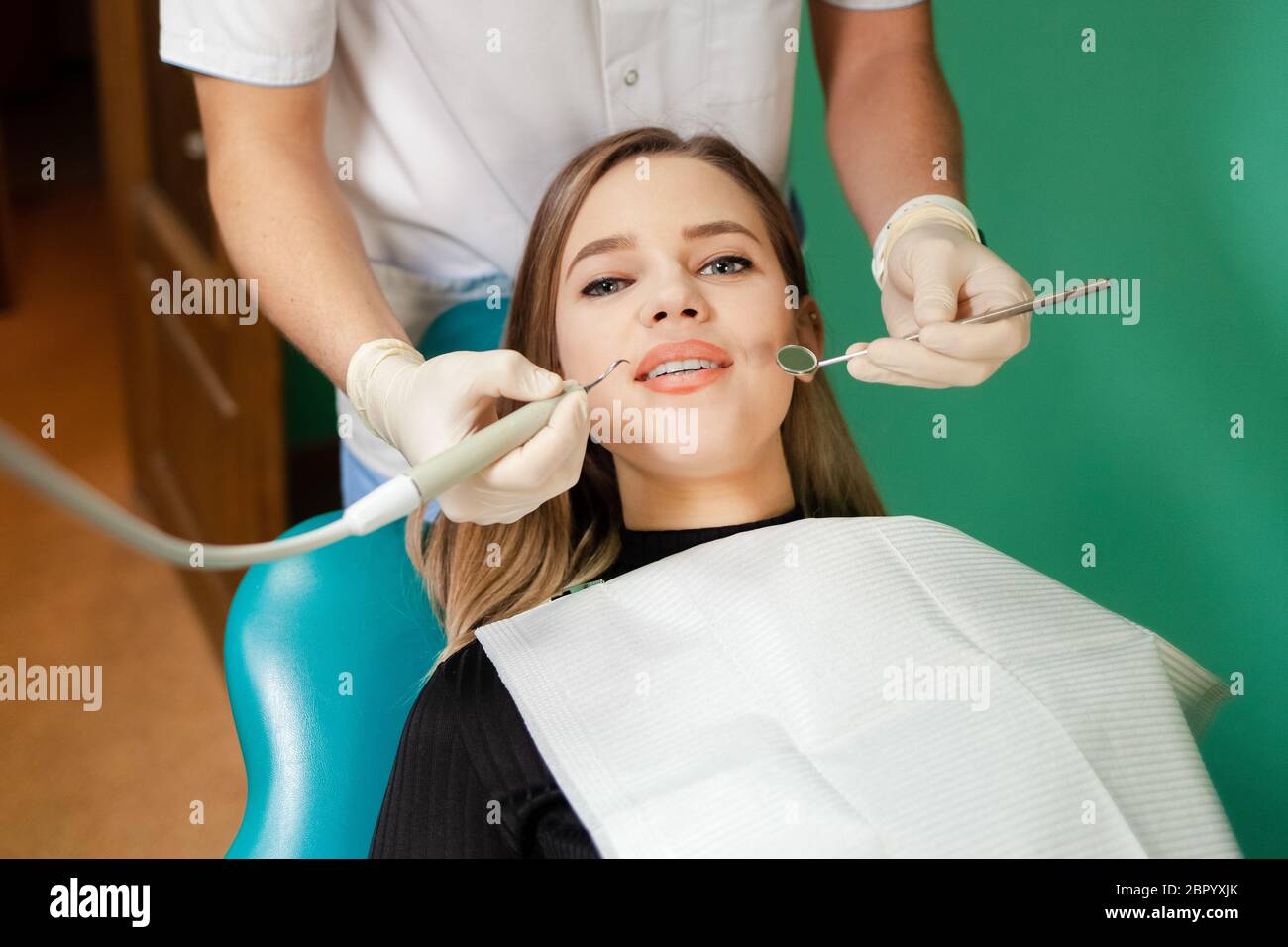 Il dentista rimuove il tartaro dai denti del paziente Foto Stock