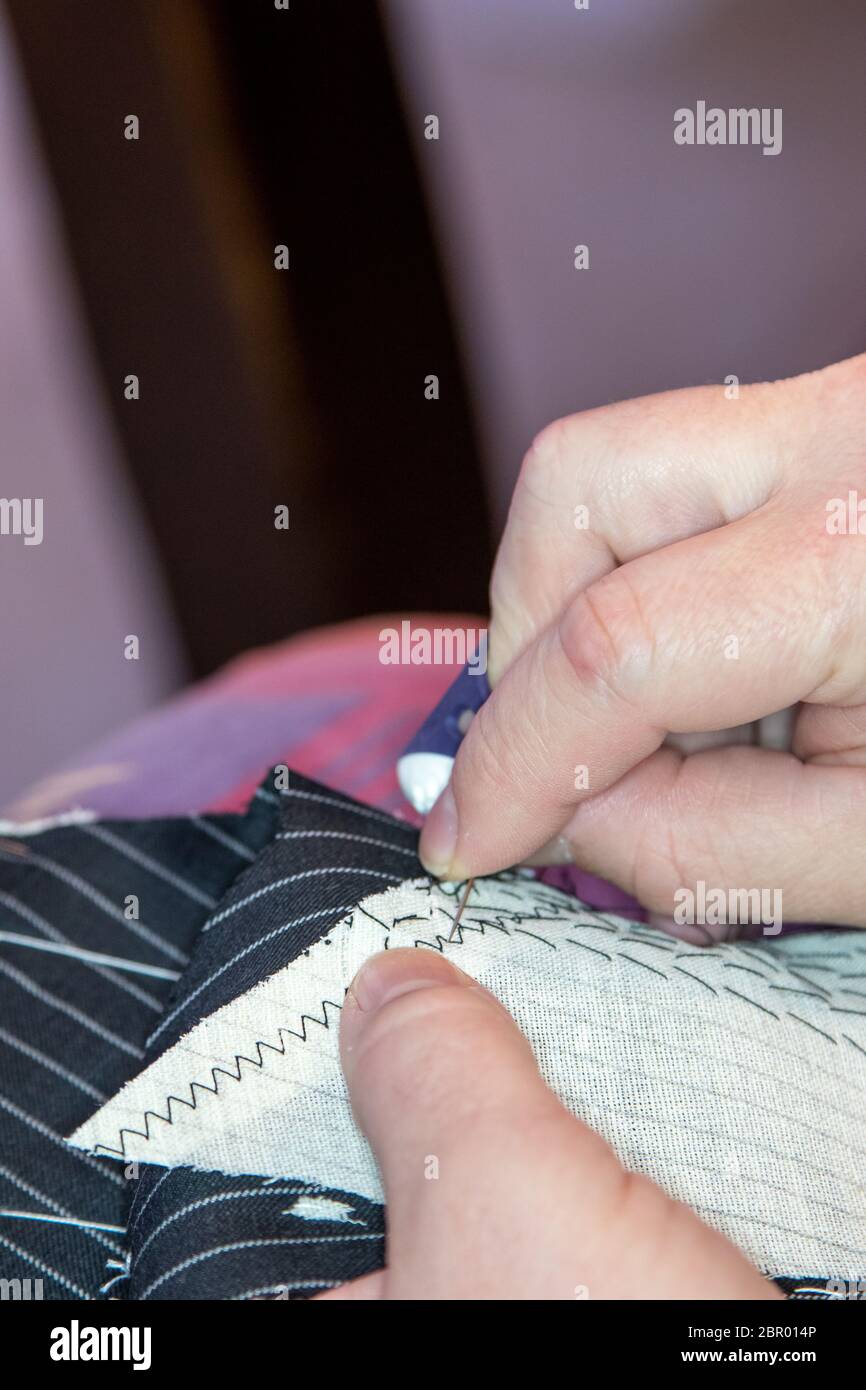 Dettagli del lavoro sarto : Sewing business suit tela a lapel. Foto Stock