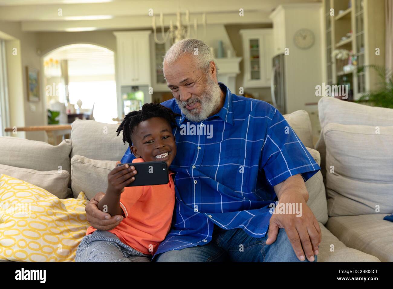 Uomo di razza misto senior con suo nipote che prende un selfie Foto Stock