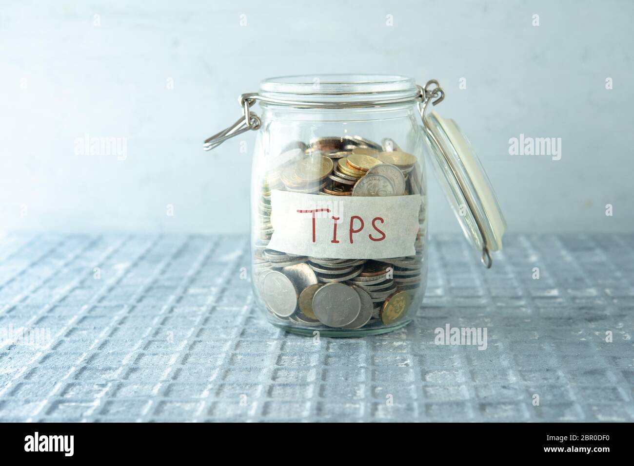 Monete in denaro di vetro vaso con suggerimenti etichetta, concetto finanziario. Foto Stock