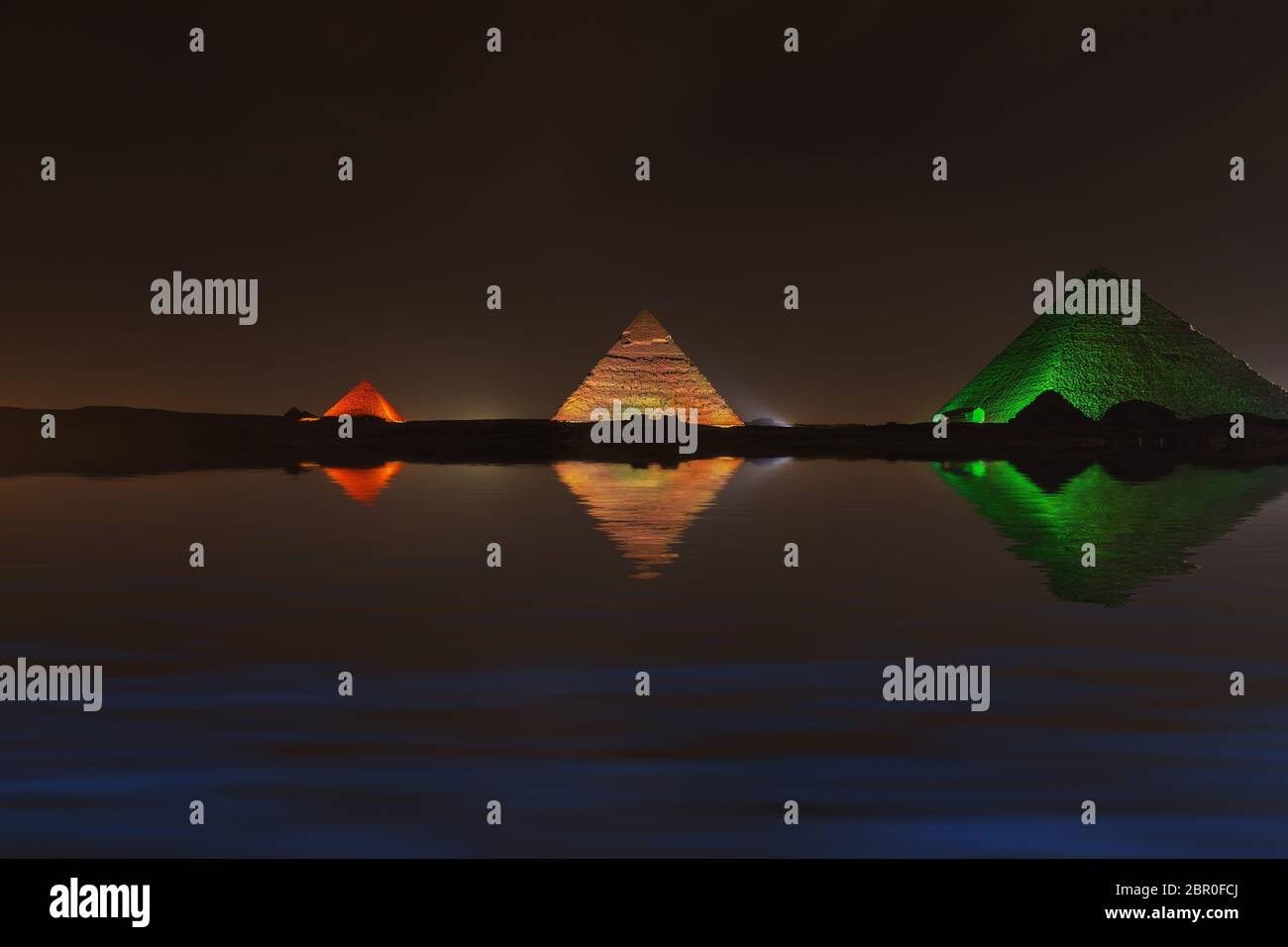 Grandi piramidi di Giza di notte, riflesso d'acqua. Foto Stock