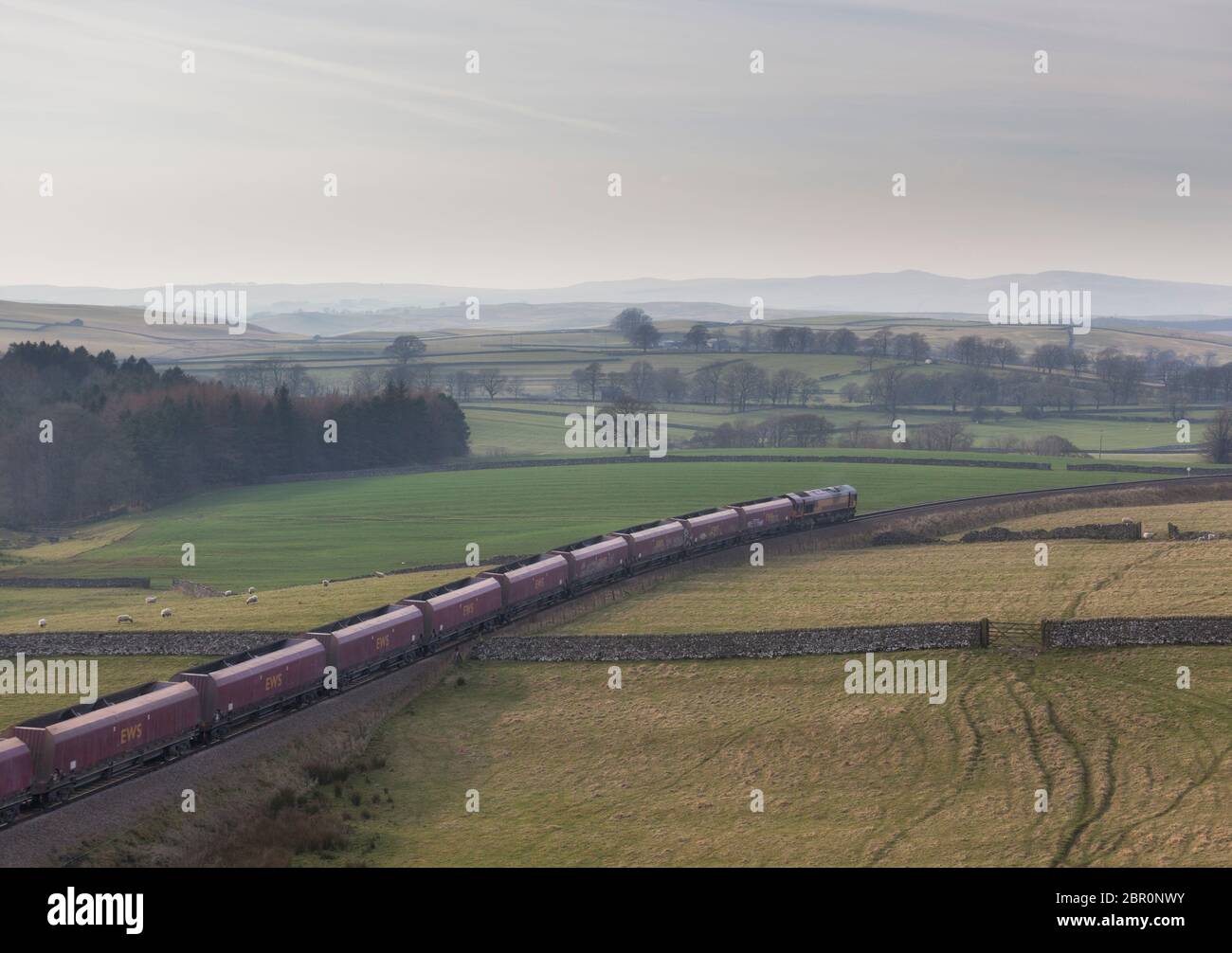 DB cargo classe 66 locomotiva 66174 trasporto di un treno di aggregati su una sola pista Rylstone solo ramo di trasporto vicino a Skipton, Yorkshire Foto Stock